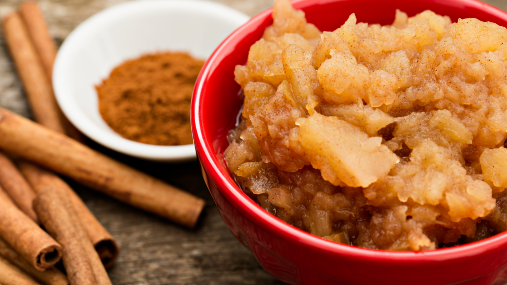 cinnamon sticks, ground cinnamon, and some mashed apples in a red bowl