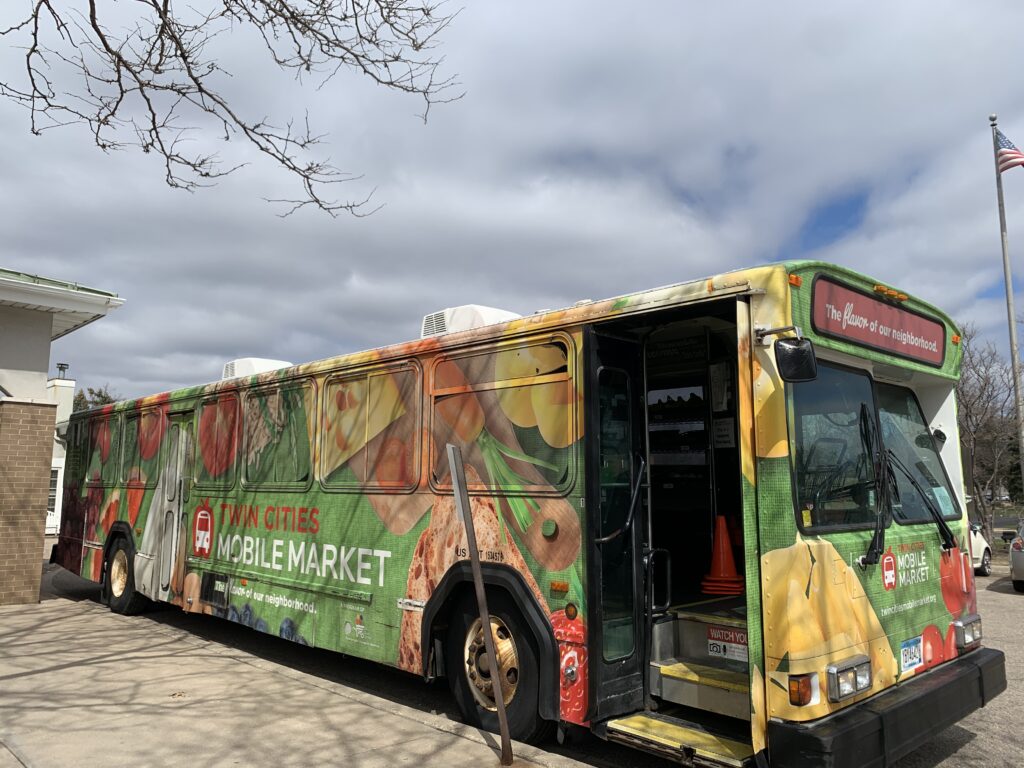 Outdoor photo of the Twin Cities Mobile Market, a colorful bus