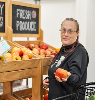 Person offering fresh apples.