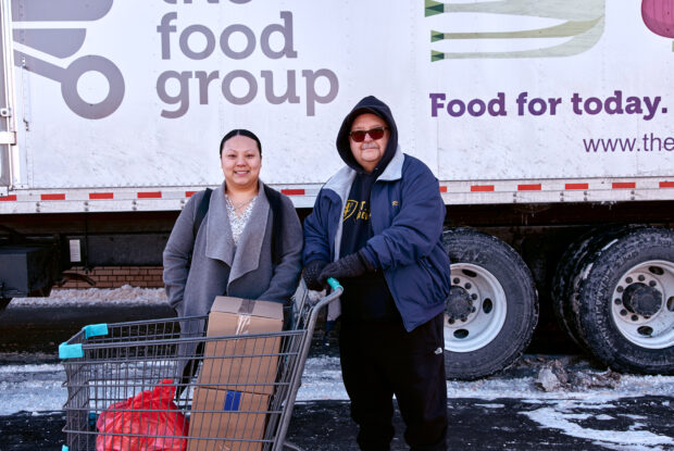 Participants receiving a cart of fresh food from the Food Group.