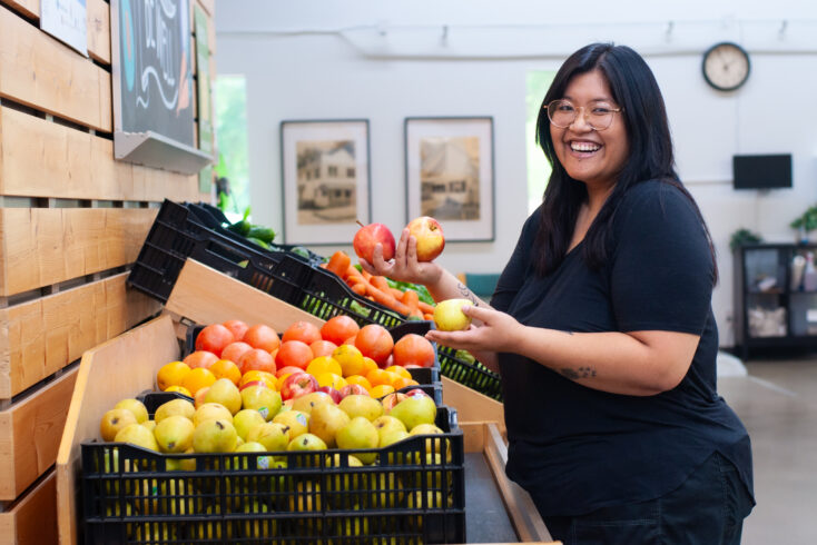 Woman at food shelf picking out fruits.