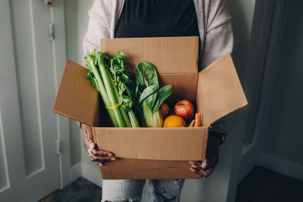 Fare For All participant holding produce box.