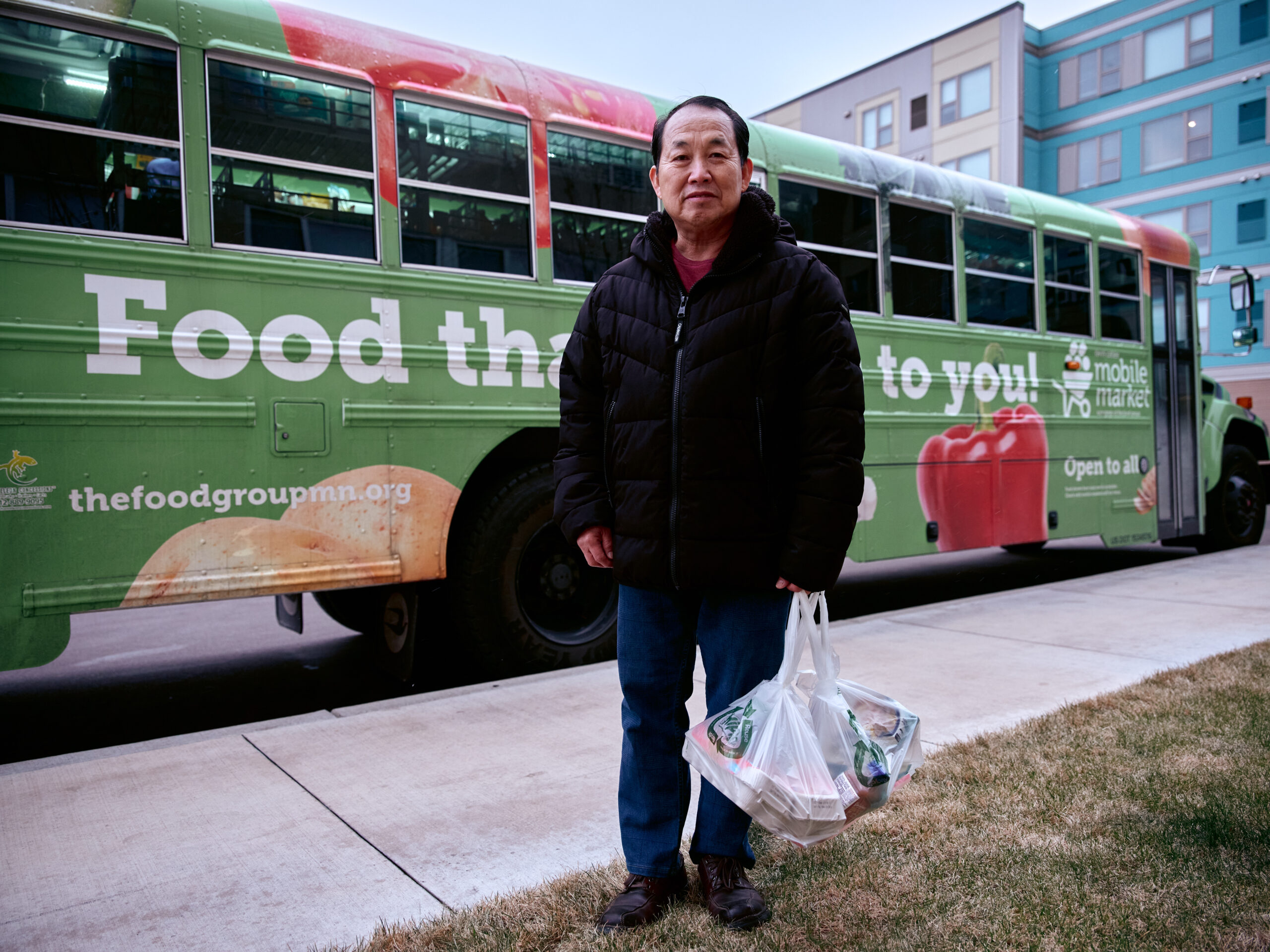 Twin Cities Mobile Market standing in front of bus.