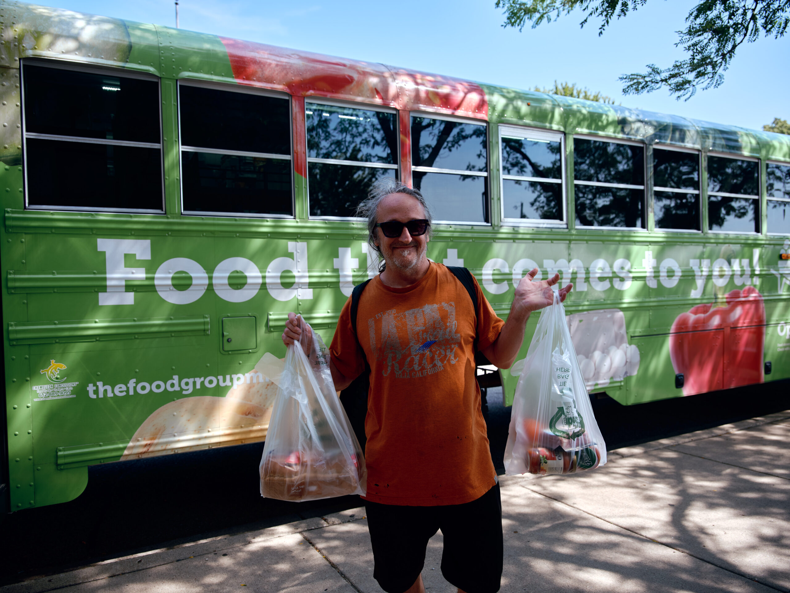 Twin Cities Mobile Market holding bags of grocery.