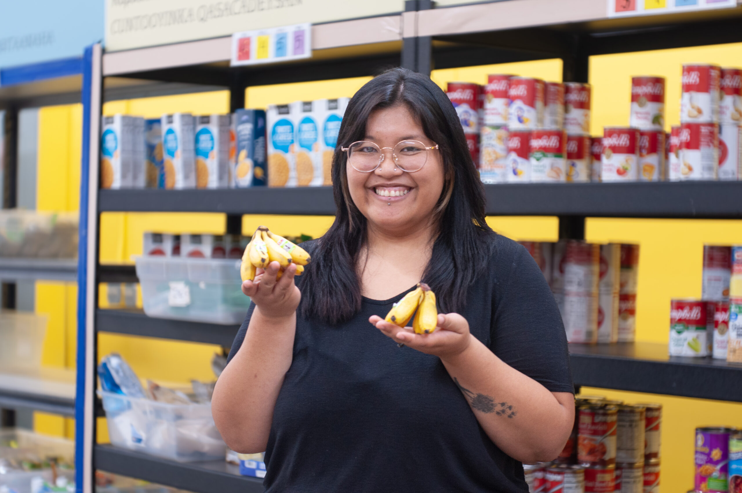 Food shelf participant holding mini bananas.
