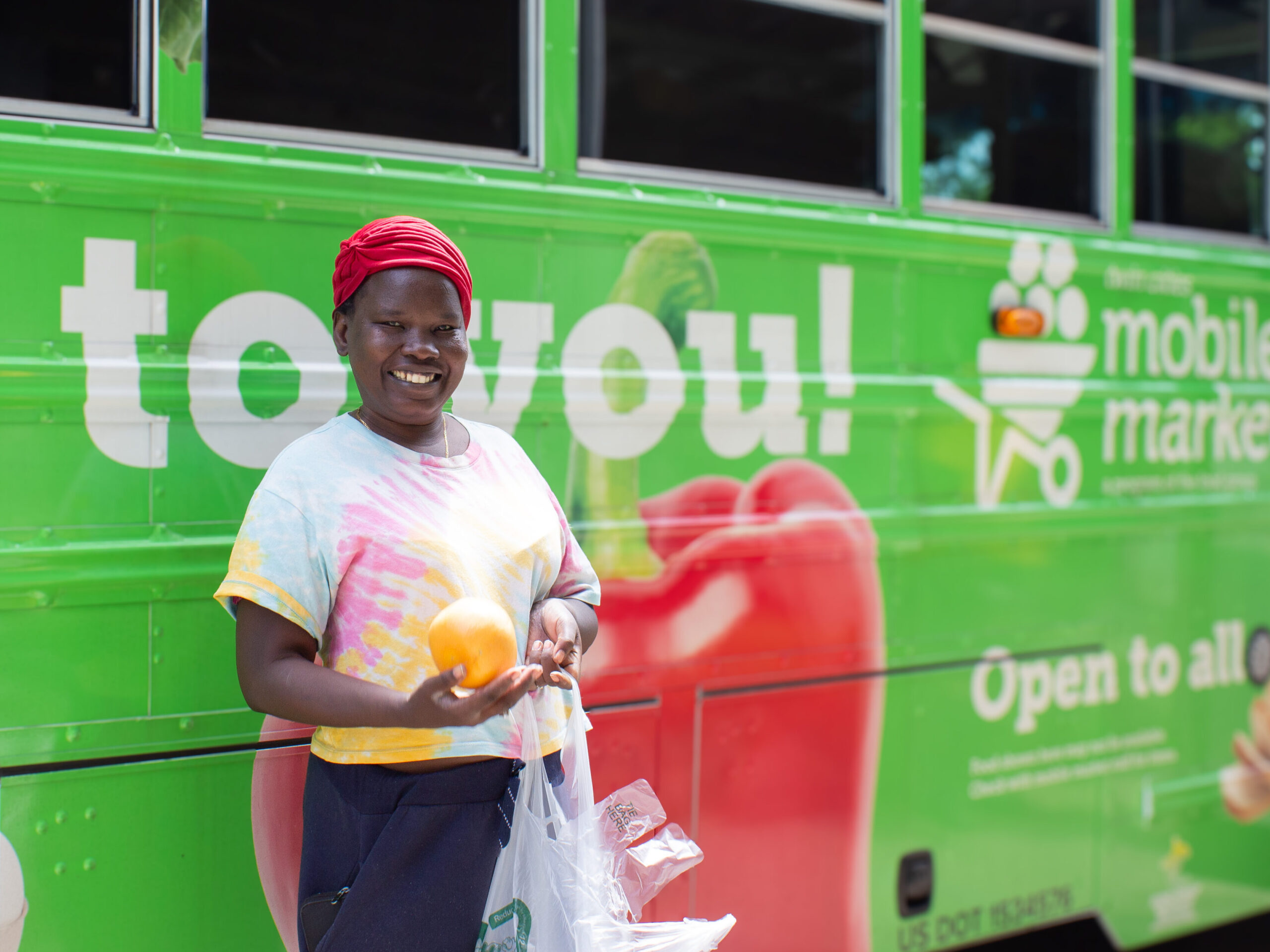 Woman holding grocery after shopping on the Twin Cities Mobile Market bus.