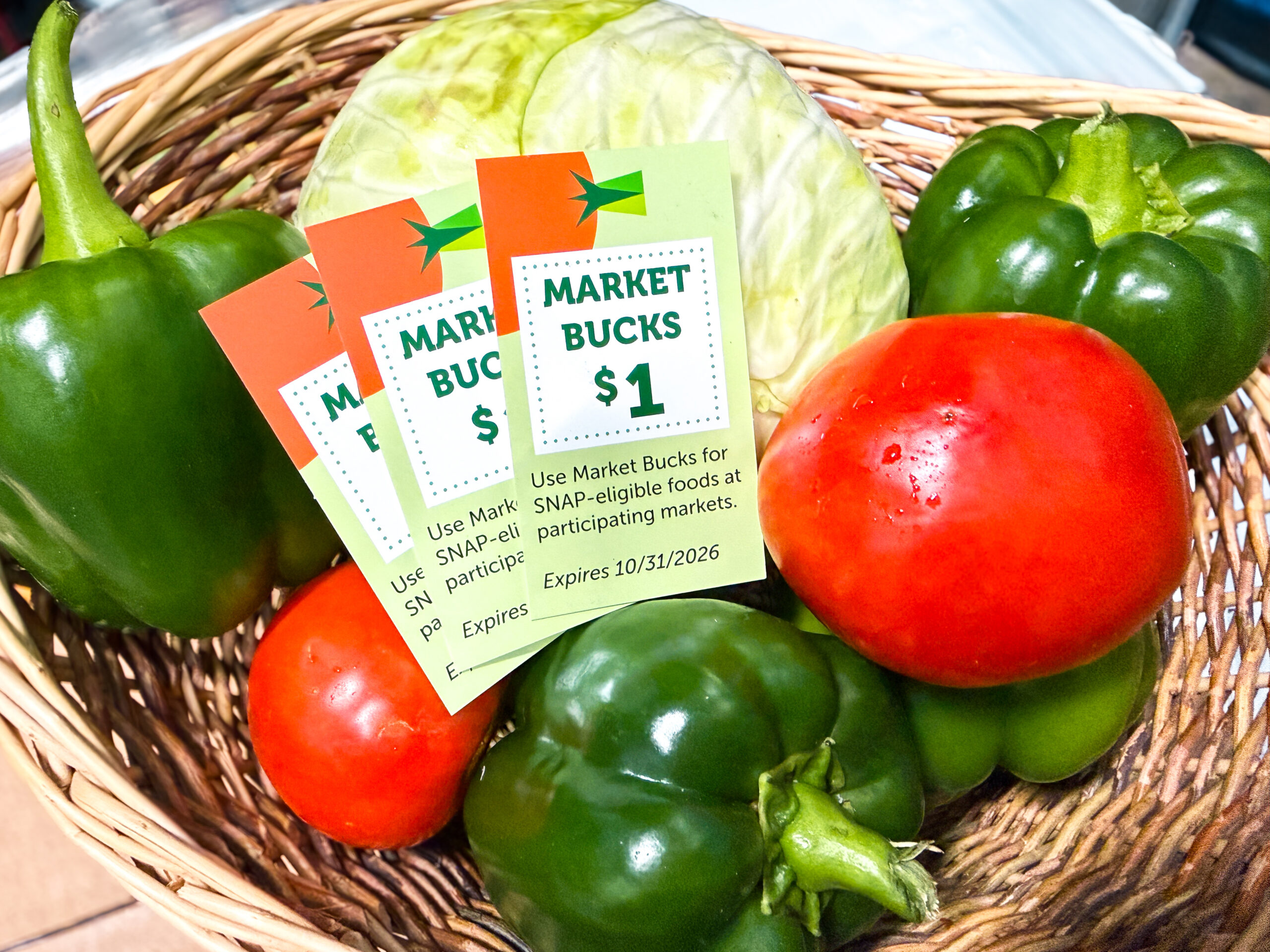 Multiple market bucks coupons in a produce basket.
